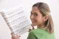 Attractive Young Woman Holding Sheet Music