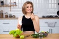 Attractive young woman holding vitamin capsule and glass of water at the kitchen. Beauty supplement. Royalty Free Stock Photo