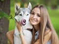 Attractive young woman hugs funny siberian husky dog