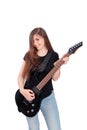 Attractive, young woman with long hair in blue jeans and a black t-shirt plays an electric guitar isolated on a white background Royalty Free Stock Photo