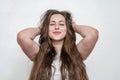 Attractive young woman with long hair and closed eyes is smiling. Hands behind the head Royalty Free Stock Photo