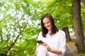 Attractive young woman looking at her smart phone and smiling Royalty Free Stock Photo