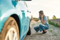 Attractive young woman looking sad, calling car service, assistance or tow truck while having troubles with her auto Royalty Free Stock Photo