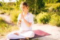 Attractive young woman is meditating and doing breathing exercising sitting in pose of lotus Royalty Free Stock Photo