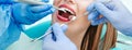 Attractive young woman with natural white teeth in dental clinic. Hands doctor dentist with medical tools. Healthy teeth concept