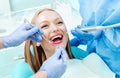 Attractive young woman with natural white teeth in dental clinic. Hands doctor dentist with medical tools. Healthy teeth concept