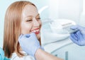 Attractive young woman with natural white teeth in dental clinic. Hands doctor dentist with teeth color palette next by face. Royalty Free Stock Photo