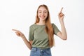 Attractive young woman with perfect smile, pointing fingers sideways, showing left and right banners, two choices, pick Royalty Free Stock Photo