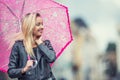 Attractive young woman with pink umbrella in the rain and strong wind. Girl with umbrella in autumn weather Royalty Free Stock Photo