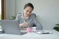 Attractive young woman putting coin into piggy bank. Saving money for future, business investment finance accounting Royalty Free Stock Photo