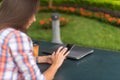 Attractive young woman reading a text message on her cell phone. Girl sitting outdoors using smartphone Royalty Free Stock Photo