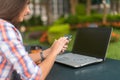 Attractive young woman reading a text message on her cell phone. Girl sitting outdoors using smartphone Royalty Free Stock Photo