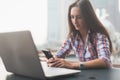 Attractive young woman reading a text message on her cell phone. Girl sitting outdoors using smartphone Royalty Free Stock Photo