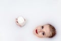 Attractive young woman with red lips lying in milk spa holding a glass of milk Royalty Free Stock Photo