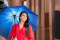 Attractive young woman in a red shirt posing with a blue umbrella Royalty Free Stock Photo