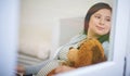 Shes already bought babys first teddy. an attractive young woman relaxing with a teddy bear on the sofa at home. Royalty Free Stock Photo