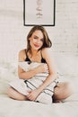 Attractive young woman in lingerie sitting in bed with a pillow Royalty Free Stock Photo