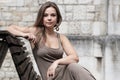 Attractive young woman sitting on a bench in front of a church Royalty Free Stock Photo