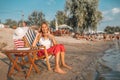 Girl talking on a phone and drinking juice on the beach