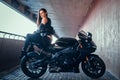 Attractive brave woman is sitting on her motobike in tunnel