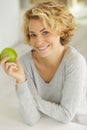 attractive young woman smelling delicious green apple