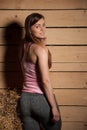 Attractive young woman in sporty dress in a barn posing with hay Royalty Free Stock Photo