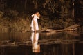 Attractive young woman standing by the lake showing her legs Royalty Free Stock Photo