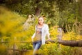 Attractive young woman standing near old wooden fence. Royalty Free Stock Photo