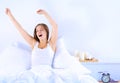An attractive young woman stretching in bed after waking up Royalty Free Stock Photo