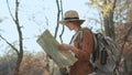 Attractive young woman in stylish hat and a tourist map in her hands looking around Royalty Free Stock Photo