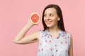 Attractive young woman in summer clothes looking aside holding half of fresh ripe grapefruit isolated on pink pastel Royalty Free Stock Photo