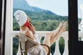 Attractive young woman in sunglasses sits on the balcony and uses the phone Perfect sunny morning Royalty Free Stock Photo