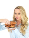 Attractive Young Woman Taking A Croissant From a Plate of Danish Pastries Royalty Free Stock Photo