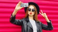 Attractive young woman taking selfie picture by phone blowing red lips sending sweet air kiss over colorful pink Royalty Free Stock Photo