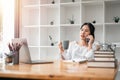 Attractive young woman talking on the mobile phone and smiling while sitting at her working place in office Royalty Free Stock Photo