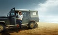 Attractive Young Woman Traveler Enjoying The Sea View, Leaning Back On a Classic Car SUV Royalty Free Stock Photo