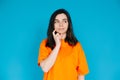 Attractive Young Woman in Trendy Orange Clothes, Pensive and Skeptical Expression, Empty Space for Copy, Isolated on Royalty Free Stock Photo