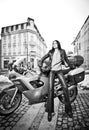 Attractive young woman in urban fashion shot near motorcycle. Beautiful fashionable young girl in black leather outfit Royalty Free Stock Photo