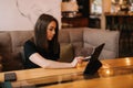 Attractive young woman uses a tablet sitting at a coffee table Royalty Free Stock Photo