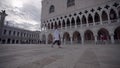 Attractive young woman walk on the square of Sanmarco in Venice Italy whit a blue sky and beautiful couds.