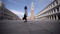 Attractive young woman walk in Venice Italy looking at the blue sky.