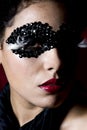 Attractive young woman wearing a black gem mask