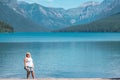Attractive young woman wearing a tank top and skirt poses at the scenery of Bowman Lake in Glacier National Park Montana Royalty Free Stock Photo