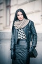 Attractive young woman in a winter fashion shot. Beautiful fashionable young girl in black leather on avenue Royalty Free Stock Photo