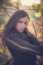 Young woman winter portrait in forest at sunset