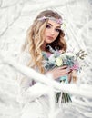 Attractive young woman in winter snow forest outdoors with flowers on her head and bouquet Royalty Free Stock Photo