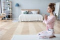 Attractive young woman working out at home, doing yoga exercise on white mat Royalty Free Stock Photo