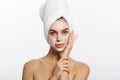 Attractive Young Woman Wrapped with Bath Towels, Applying Cream on her Face After a Shower at the Bathroom. Royalty Free Stock Photo