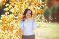 Attractive young woman in yellow autumn leaves, sunlight Royalty Free Stock Photo