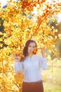 Attractive young woman in yellow autumn leaves, sunlight Royalty Free Stock Photo